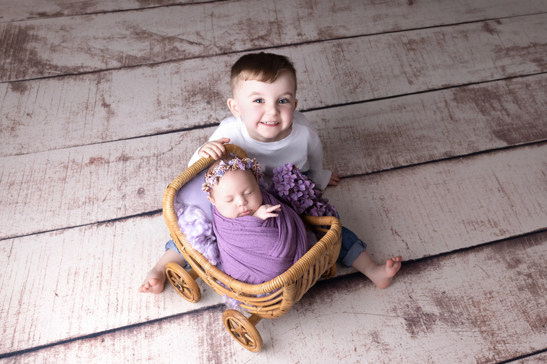 Photographie de naissance, la maman tient dans ses bras son bébé et lui fait un bisou sur le front