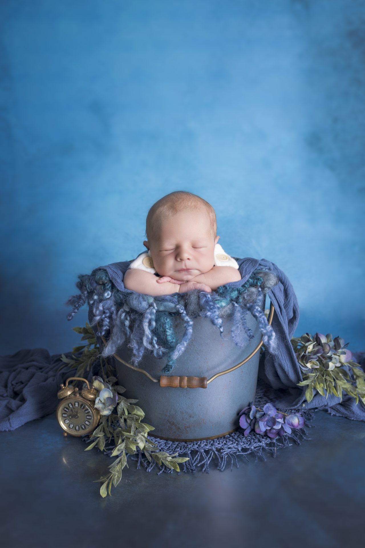 Photographie d"une femme enceinte aux cheveux long châtain aux pointes plus claires, cheveux ondulé. elle est nue avec un bijou de corp. Ses mains cache sa poitrine et un effet de lumiere bleu et reouge teinte sa peau. Photographie de grossesse capturée par Del'Clic Studio, photographe située à abancourt proche de cambrai, douai, lille, valenciennes, arras, amiens, aniche, somain, Nord-Pas-de-Calais