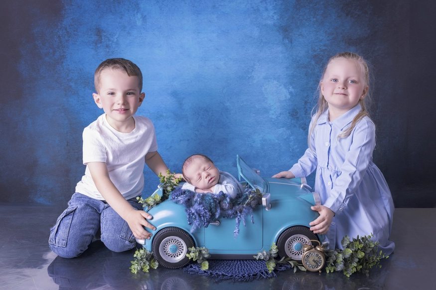 Photographie de naissance, la maman tient dans ses bras son bébé et lui fait un bisou sur le front