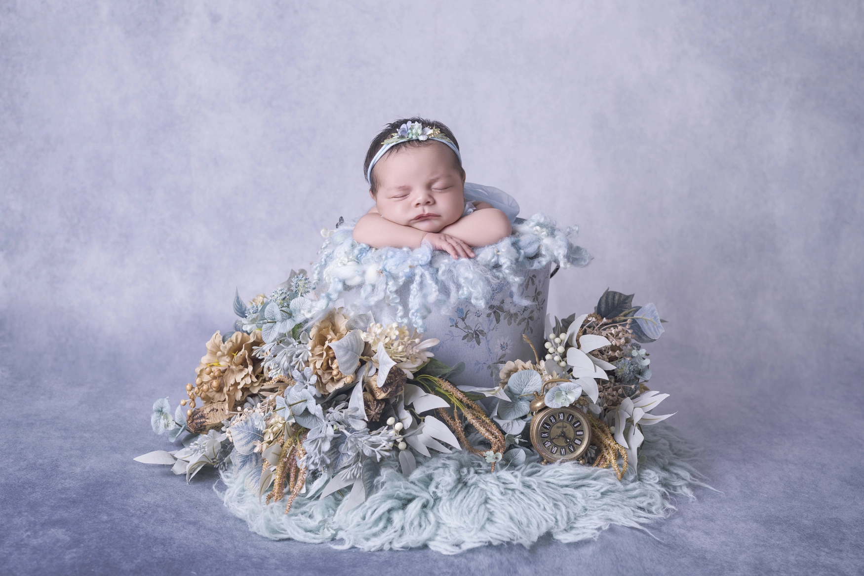 Photographie de naissance, la maman tient dans ses bras son bébé et lui fait un bisou sur le front