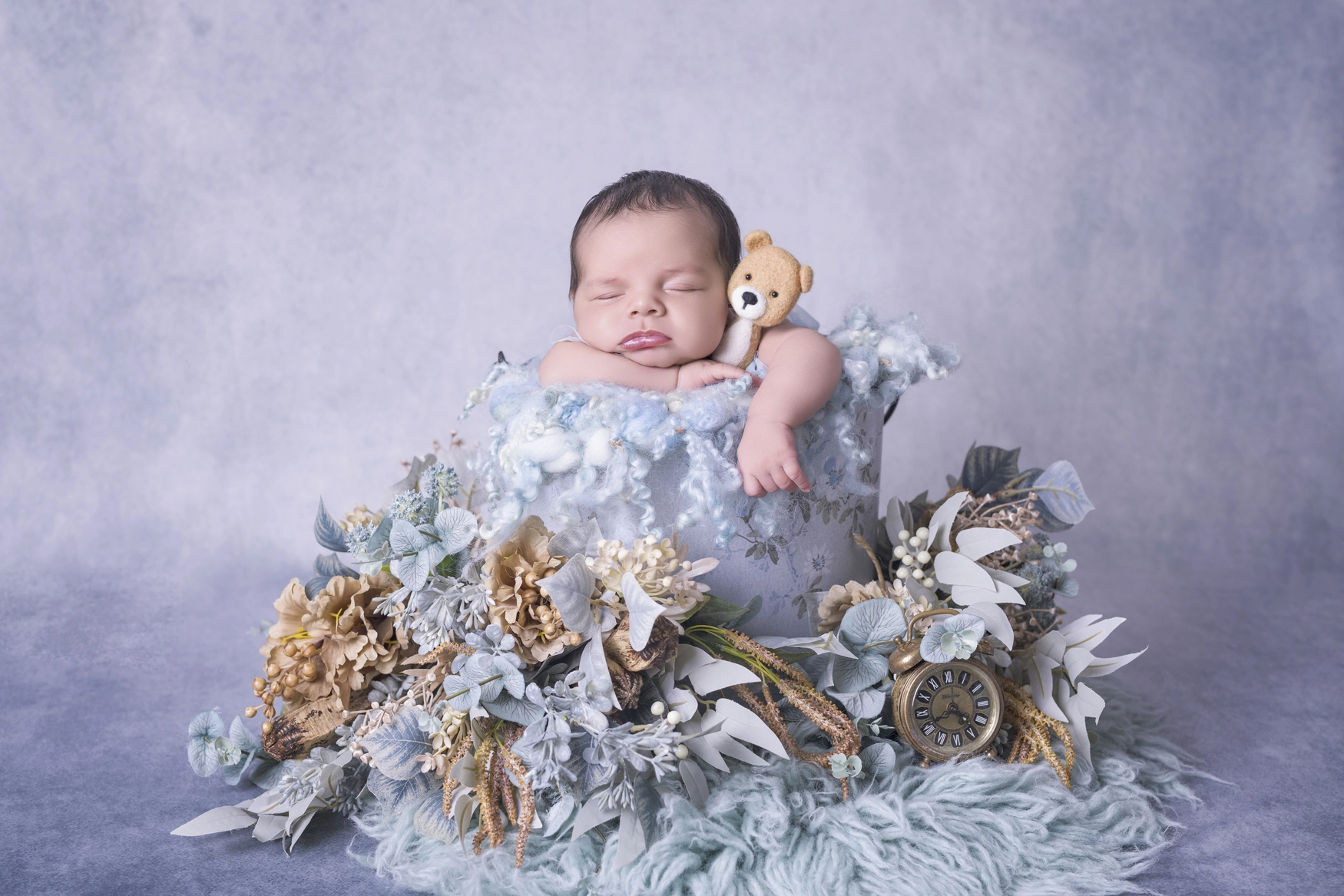 Photographie de naissance, la maman tient dans ses bras son bébé et lui fait un bisou sur le front