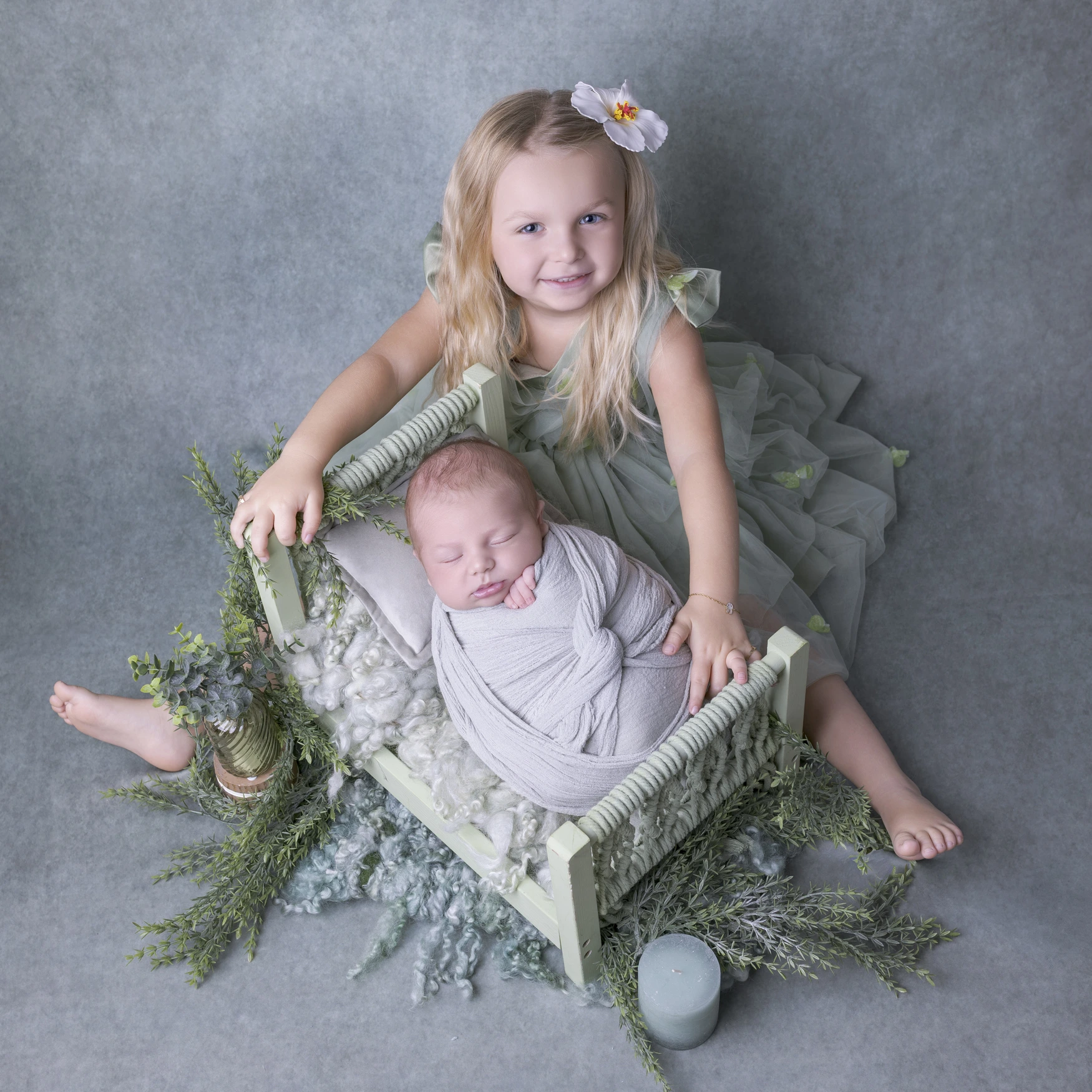 Photographie de naissance, la maman tient dans ses bras son bébé et lui fait un bisou sur le front