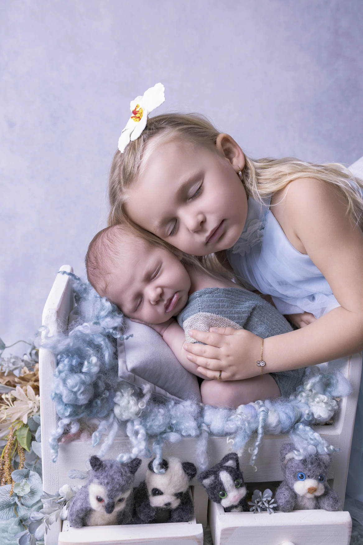 Photographie de naissance, la maman tient dans ses bras son bébé et lui fait un bisou sur le front