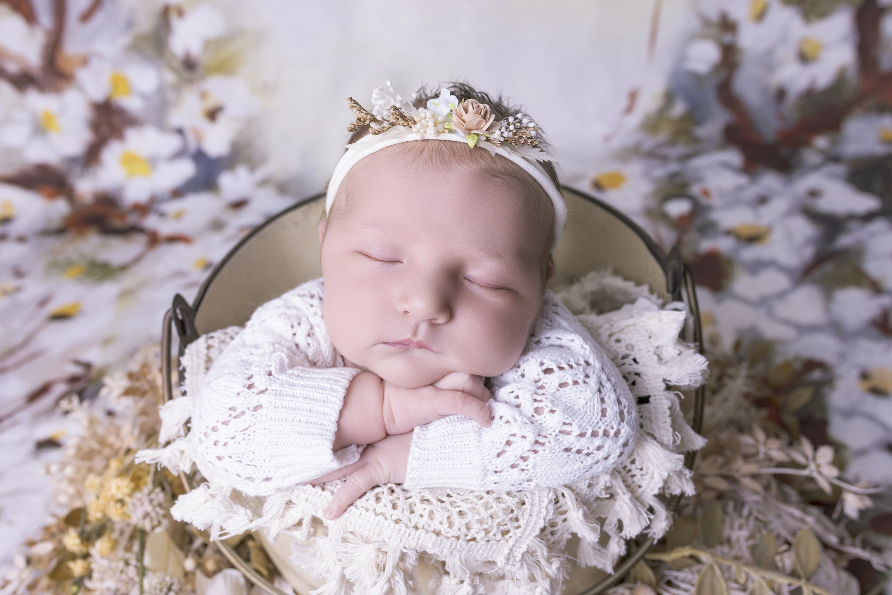 Photographie de naissance, la maman tient dans ses bras son bébé et lui fait un bisou sur le front