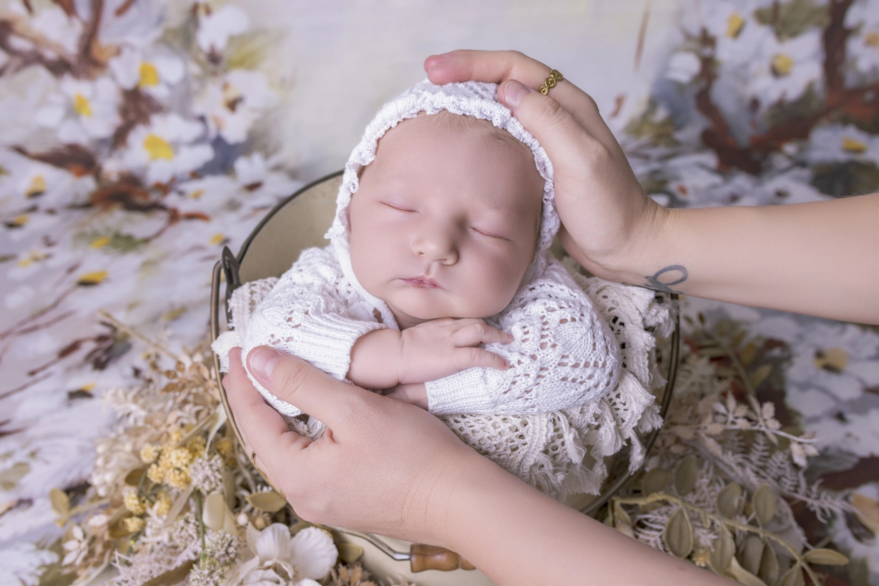 Photographie de naissance, la maman tient dans ses bras son bébé et lui fait un bisou sur le front